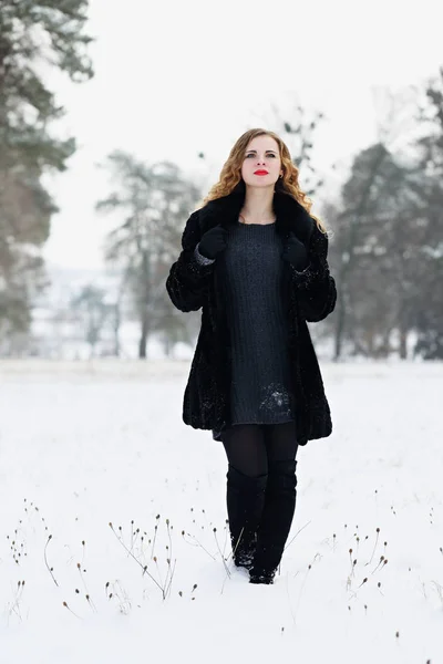 Mulher andando em um campo nevado — Fotografia de Stock