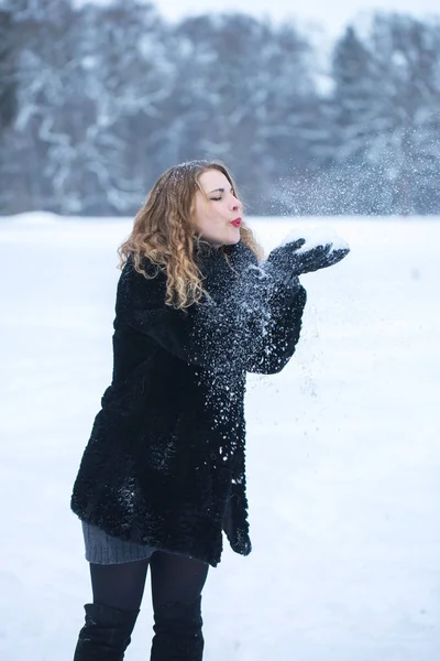 Kvinna blåser på snöflingor — Stockfoto
