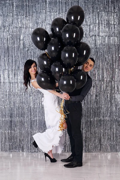 Jovem casal com bolas pretas — Fotografia de Stock