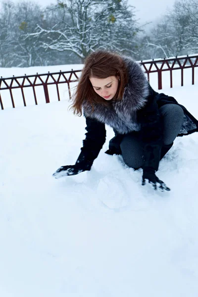 Mujer está haciendo una pelota de la nieve —  Fotos de Stock