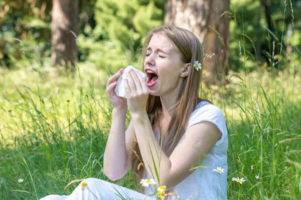 Woman sneezing in the woods — Stock Photo, Image