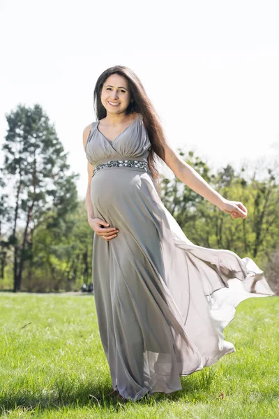 Mujer embarazada en un prado de primavera — Foto de Stock