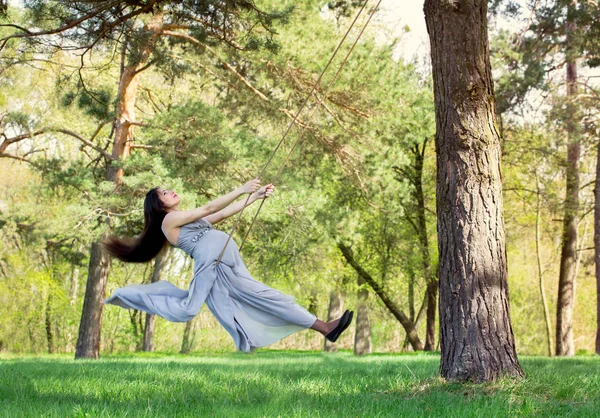 Pregnant woman swinging on a swing — Stock Photo, Image