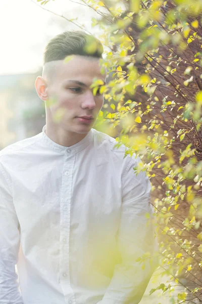 Jeune homme avec des feuilles d'automne — Photo