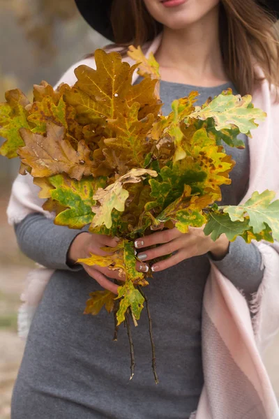 Woman with a bouquet of oak branches — Stock Photo, Image