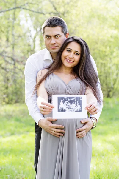 Couple enceinte avec une photo d'un enfant — Photo