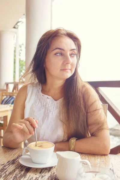 Una mujer está bebiendo capuchino — Foto de Stock