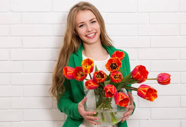 Woman with a vase of tulips — Stock Photo, Image