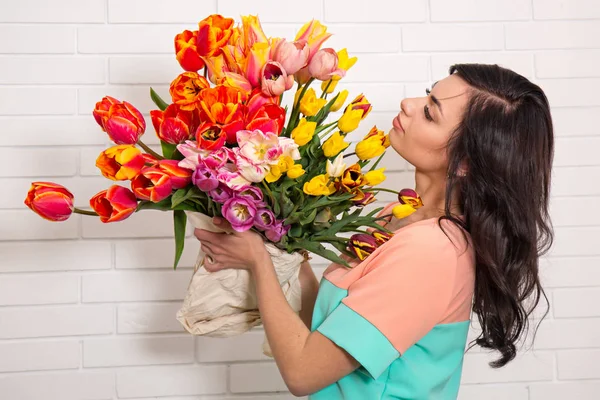 Vrouw met een grote boeket tulpen — Stockfoto