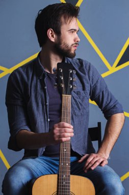 adamın elinde bir gitar