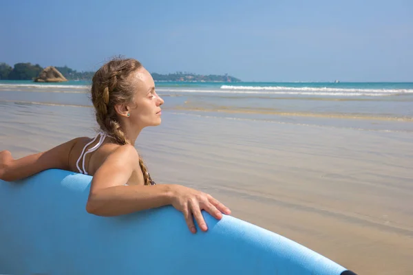 Chica con tabla de surf descansando en la playa —  Fotos de Stock