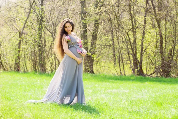 Těhotná žena chodí na louce — Stock fotografie