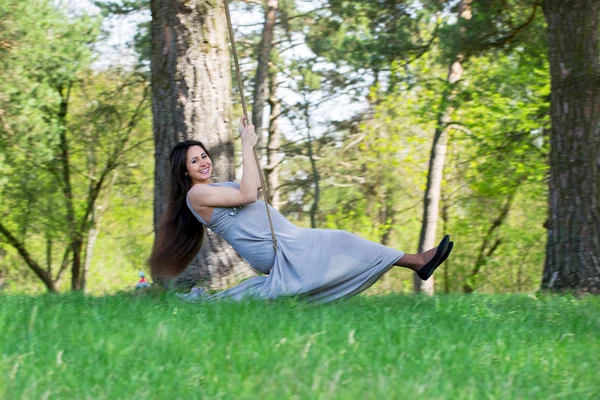 Zwangere vrouw op een schommel — Stockfoto