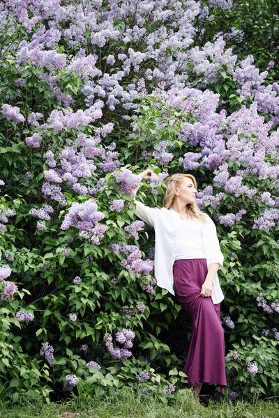 Mulher perto do lilás florescente — Fotografia de Stock