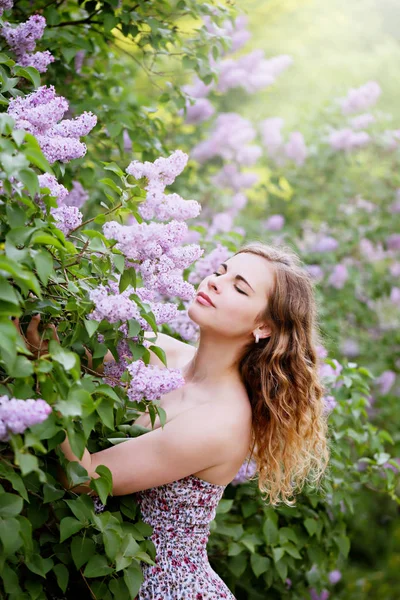 Ung kvinna att lukta en lila — Stockfoto