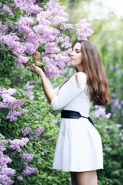 Menina cheirando um lilás — Fotografia de Stock