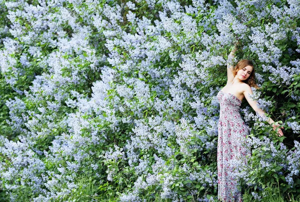 女孩享受盛开的丁香花 — 图库照片