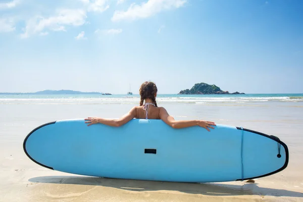 Menina com prancha de surf descansando — Fotografia de Stock