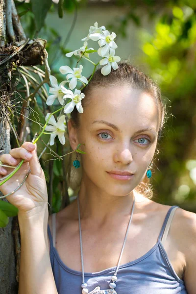 Chica con una rama de una orquídea blanca — Foto de Stock