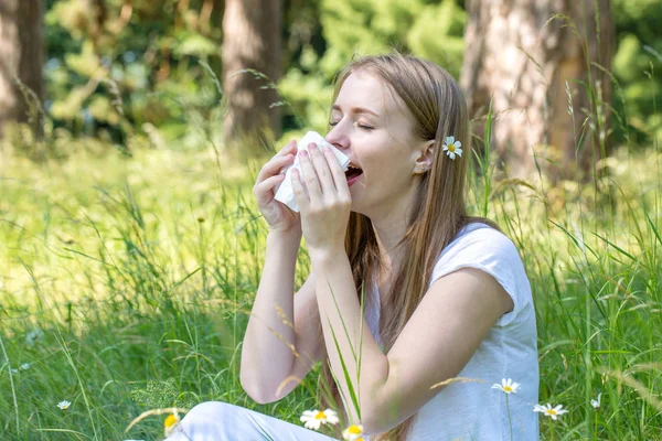 Woman in the meadow sneezes — Stock Photo, Image