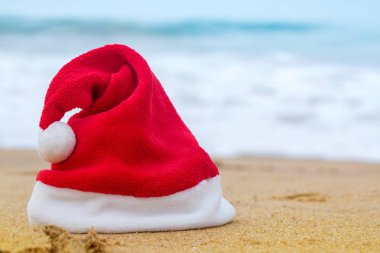 Kumlu okyanusta Noel Baba şapkası
