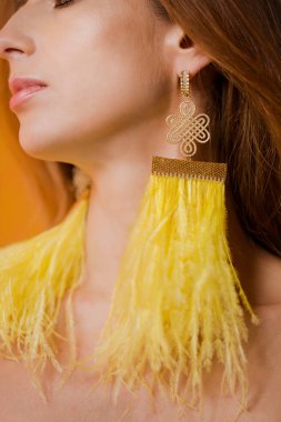 Uzun devekuşu tüyü küpeli kız.