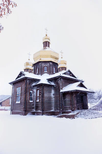 Träkyrka en snöig dag — Stockfoto