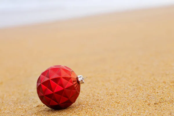 Red Christmas ball on the shore — Stock Photo, Image