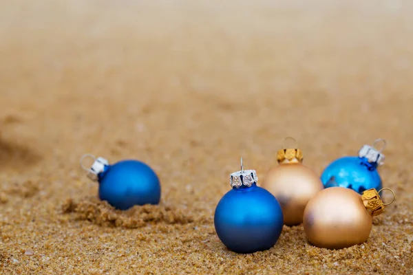 Золотые и голубые рождественские шарики на берегу — стоковое фото