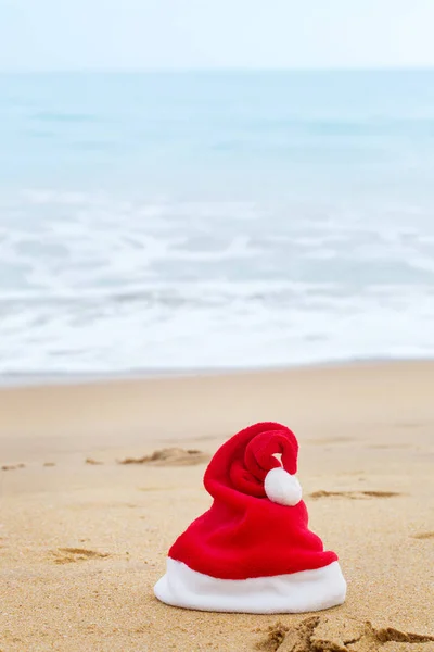 Santa Claus red hat on the sandy ocean — Stock Photo, Image