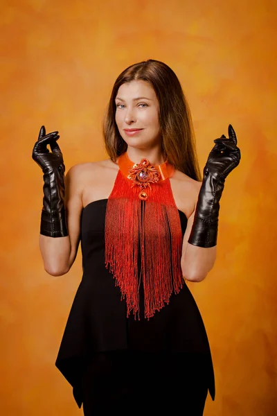 Hermosa mujer con guantes negros y un collar largo —  Fotos de Stock