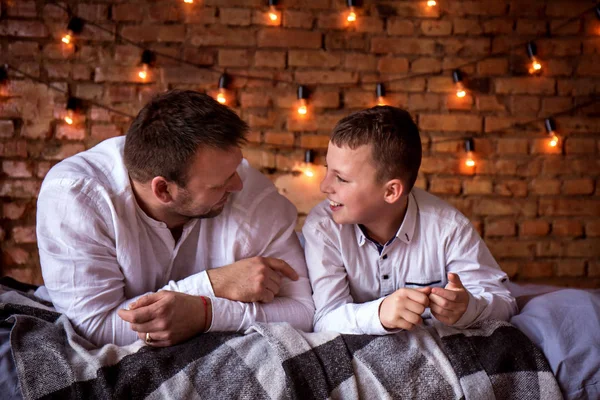 Vader en zoon praten liggen in bed — Stockfoto