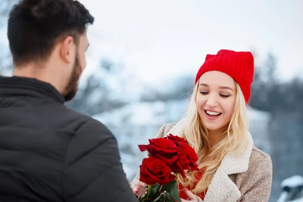 Молодая пара с красными розами на открытом воздухе — стоковое фото