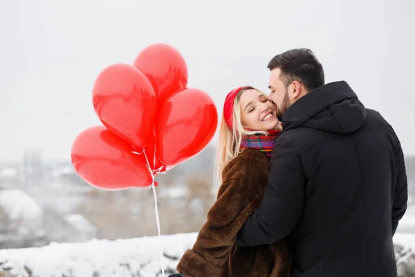 Beautiful couple with red roballs outdoors — Stock Photo, Image