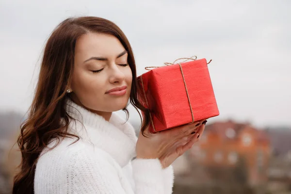 Το όμορφο κορίτσι κρατάει ένα κουτί με ένα δώρο στα χέρια της. — Φωτογραφία Αρχείου