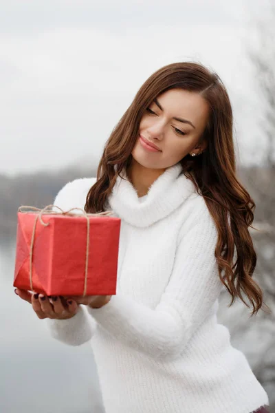 Fille tient une boîte avec un cadeau dans ses mains — Photo