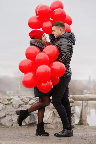 Kırmızı balonlarla yürüyen genç çift — Stok fotoğraf