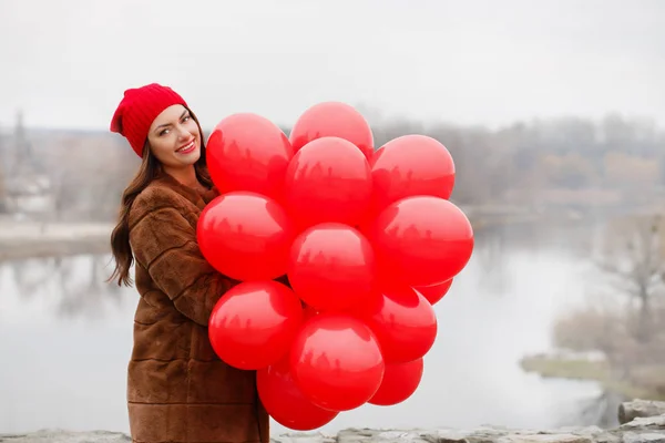 Chica sostiene un globos en sus manos —  Fotos de Stock