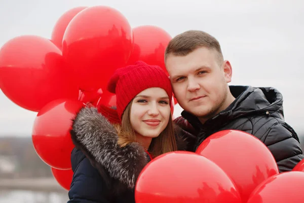 Casal jovem com balões vermelhos — Fotografia de Stock
