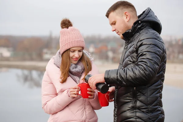 Молодая пара на пикнике зимой пьет чай — стоковое фото