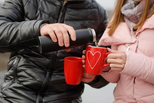 Giovane coppia a un picnic in inverno bevono tè, primo piano — Foto Stock