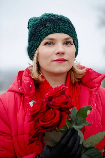 Mooie vrouw met een boeket van rode rozen — Stockfoto