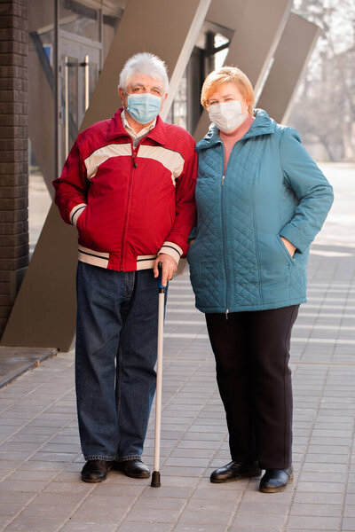 An elderly couple of people in protective masks. Coronavirus Protection Concept