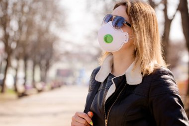 Koruyucu maskeli genç kadın yürüyor. Coronavirus Koruma Konsepti