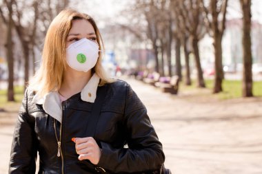 Koruyucu maskeli genç ve güzel bir kadın dışarıda yürüyor. Coronavirus Koruma Konsepti