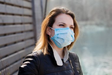 Koruyucu maskeli genç kadın yürüyor. Coronavirus Koruma Konsepti