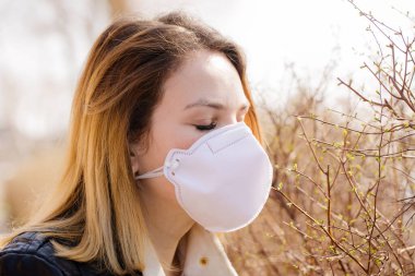 Koruyucu maskeli genç kadın yürüyor. Coronavirus Koruma Konsepti