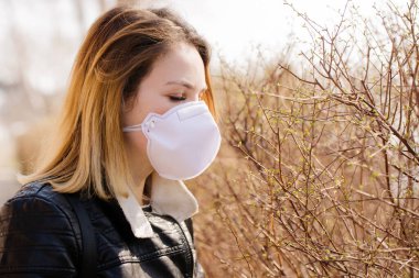 Koruyucu maskeli genç kadın yürüyor. Coronavirus Koruma Konsepti