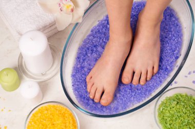 Tuz banyosunda küçük kadın bacakları, Reiki deresinde enerjik bacak temizliği.