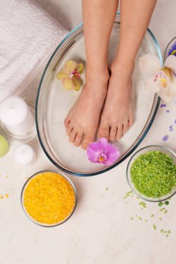 Tuz banyosunda küçük kadın bacakları, Reiki deresinde enerjik bacak temizliği.